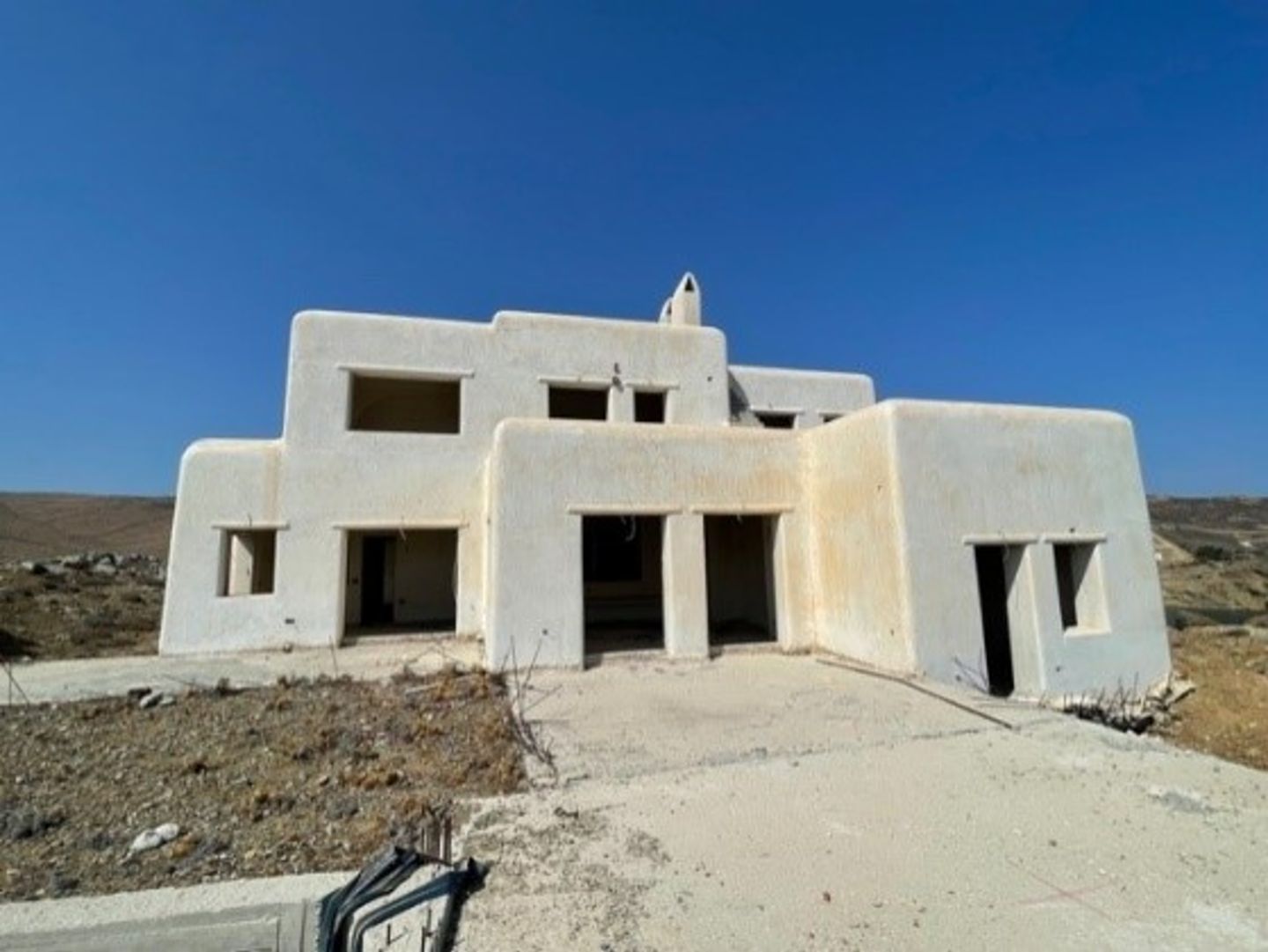 Photo of a complex with several unfinished villas on Mykonos that EOS is refurbishing to sustainable standards.