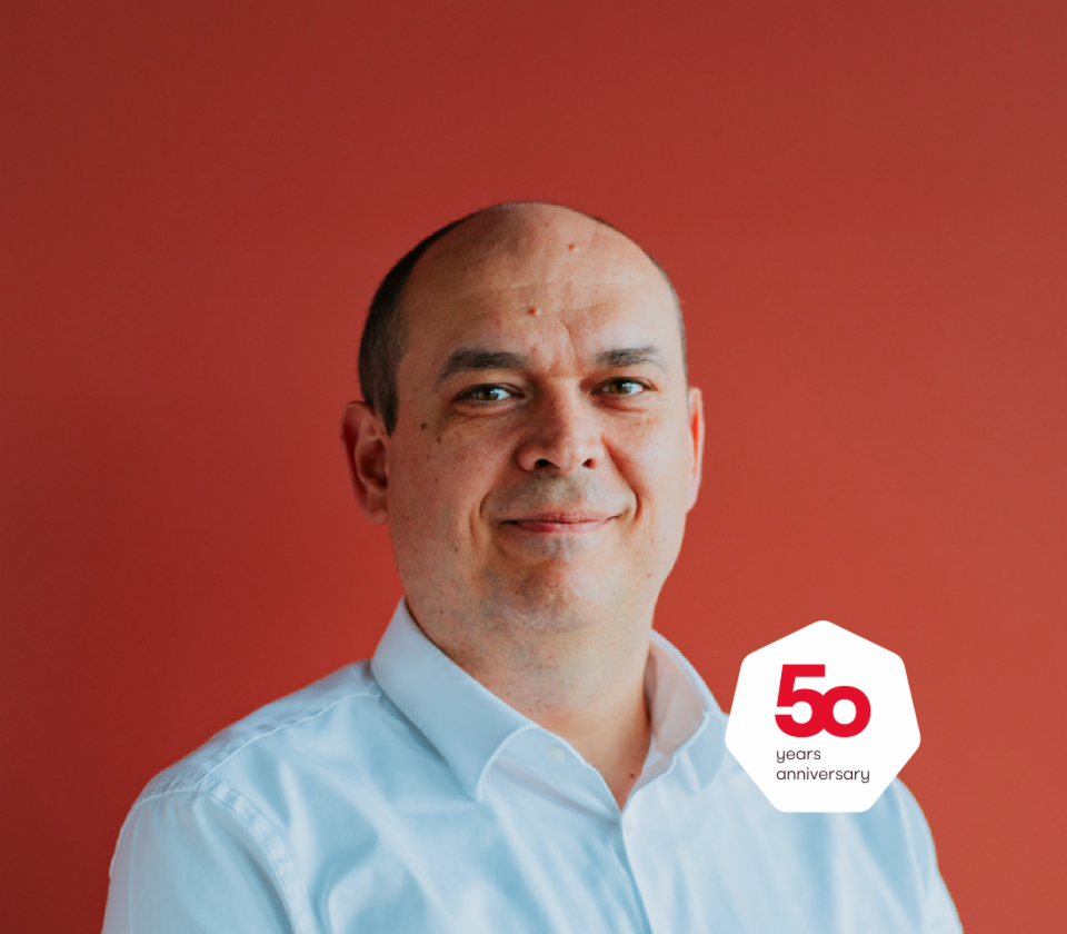 Portrait of Cristian Musat, Managing Director EOS Technology Solutions in front of a red background