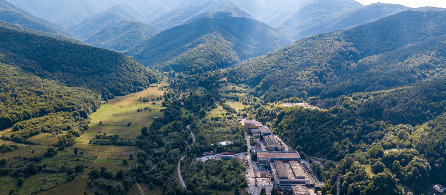 Receivables management: The image shows an aerial view of the marble factory in Berkovitsa, surrounded by many trees in a valley. Due to EOS's commitment, the traditional company was preserved.