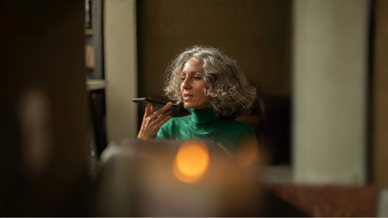 A woman holding a mobile phone is talking to AI.