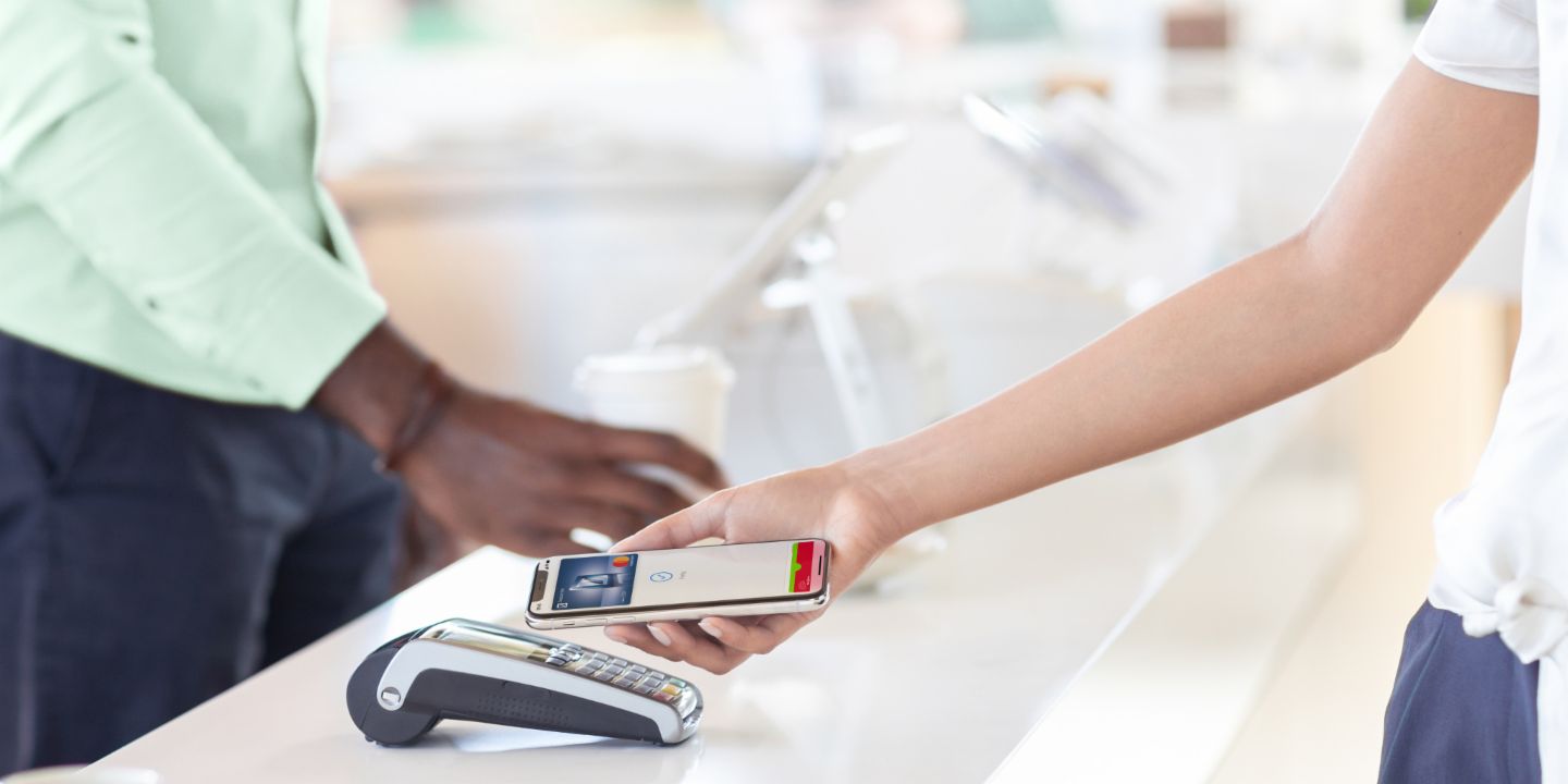 Mobile payment: Woman paying by smartphone in a shop.
