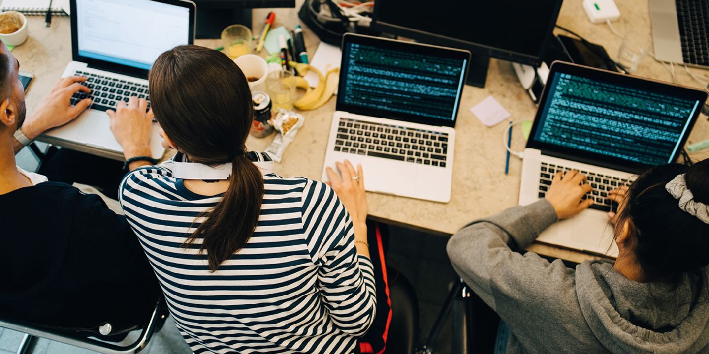 AI development in companies: A team of developers programmes some AI software.