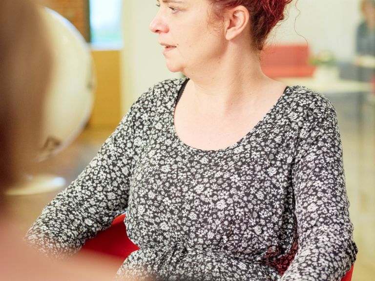 Interview: Call center agent Katja Wolf sitting in an armchair.