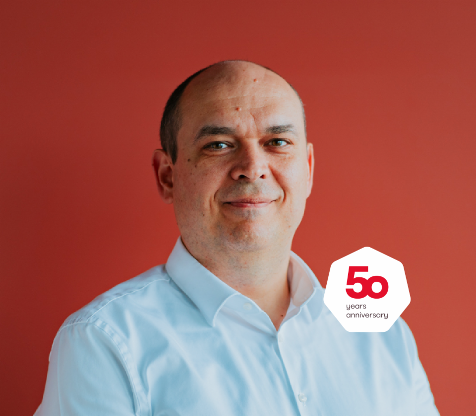 Portrait of Cristian Musat, Managing Director EOS Technology Solutions in front of a red background