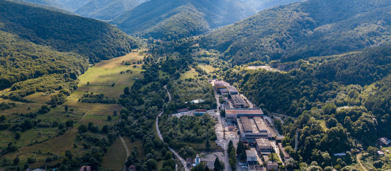 Receivables management: The image shows an aerial view of the marble factory in Berkovitsa, surrounded by many trees in a valley. Due to EOS's commitment, the traditional company was preserved.