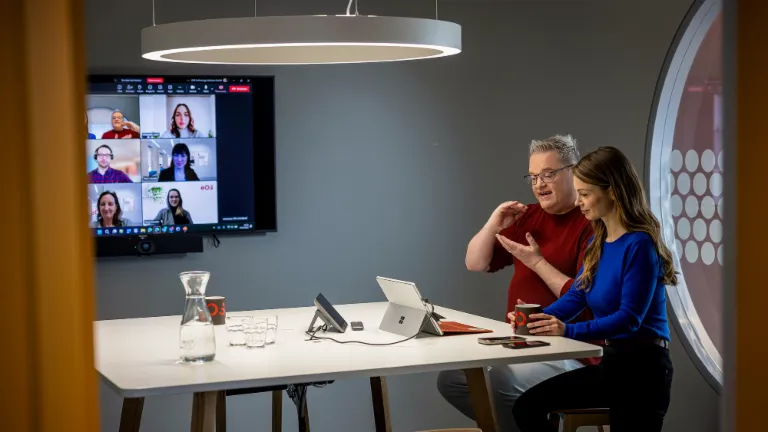 Two employees reviewing content on a tablet together – responsible corporate governance and compliance at EOS