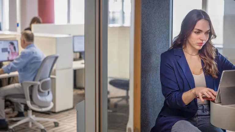 Female employee working focused on a laptop – financial sustainability and financial education at EOS