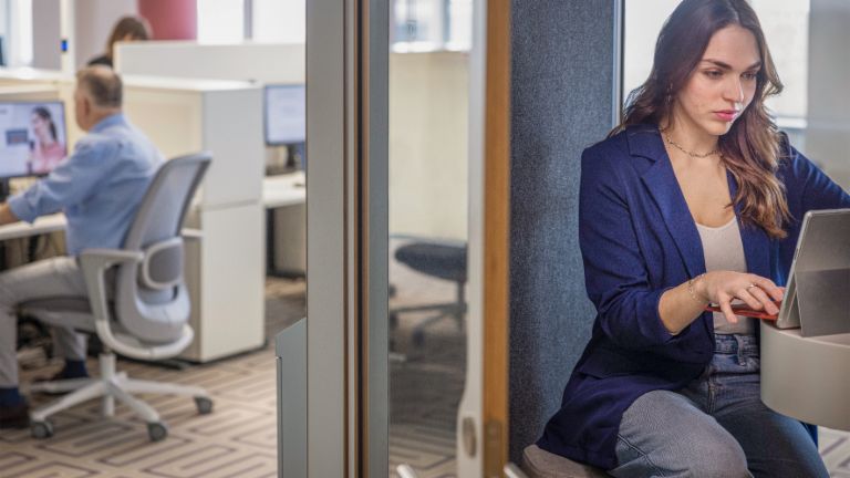 Female employee working focused on a laptop – financial sustainability and financial education at EOS