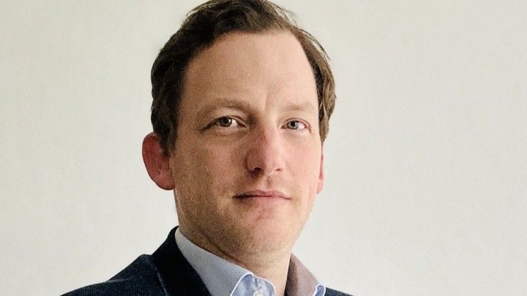 Portrait of Christian Emus in a suit facing the camera.